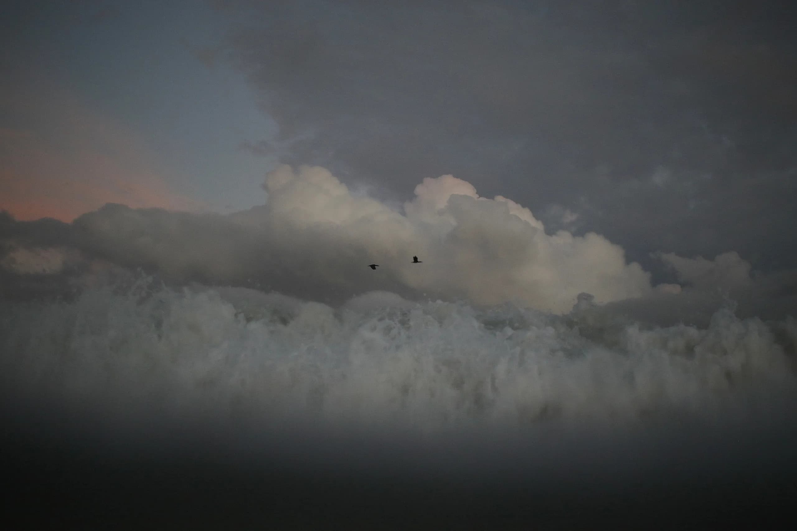 A dark ocean beneath layered storm clouds.