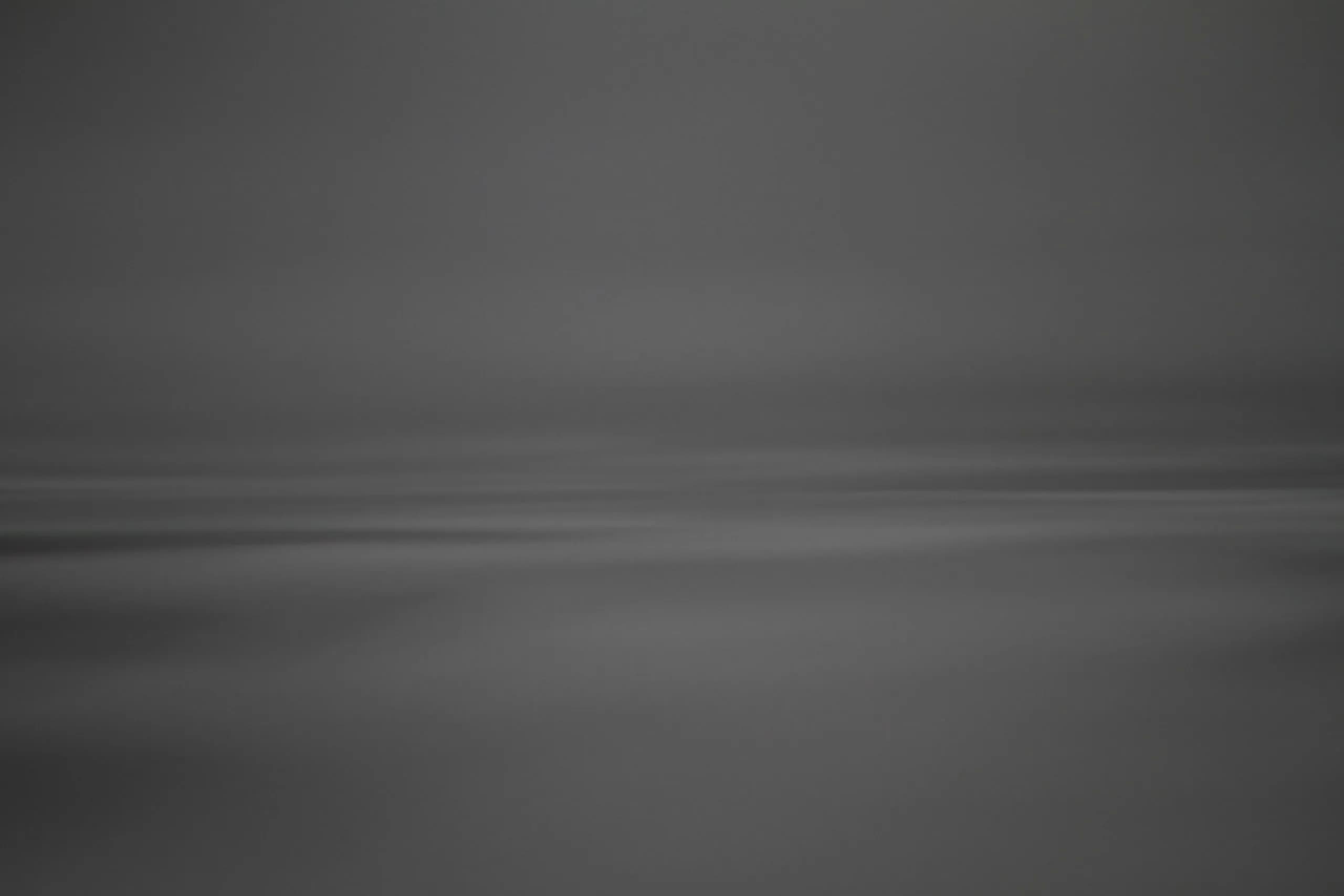 A distant ocean horizon beneath a soft grey sky.