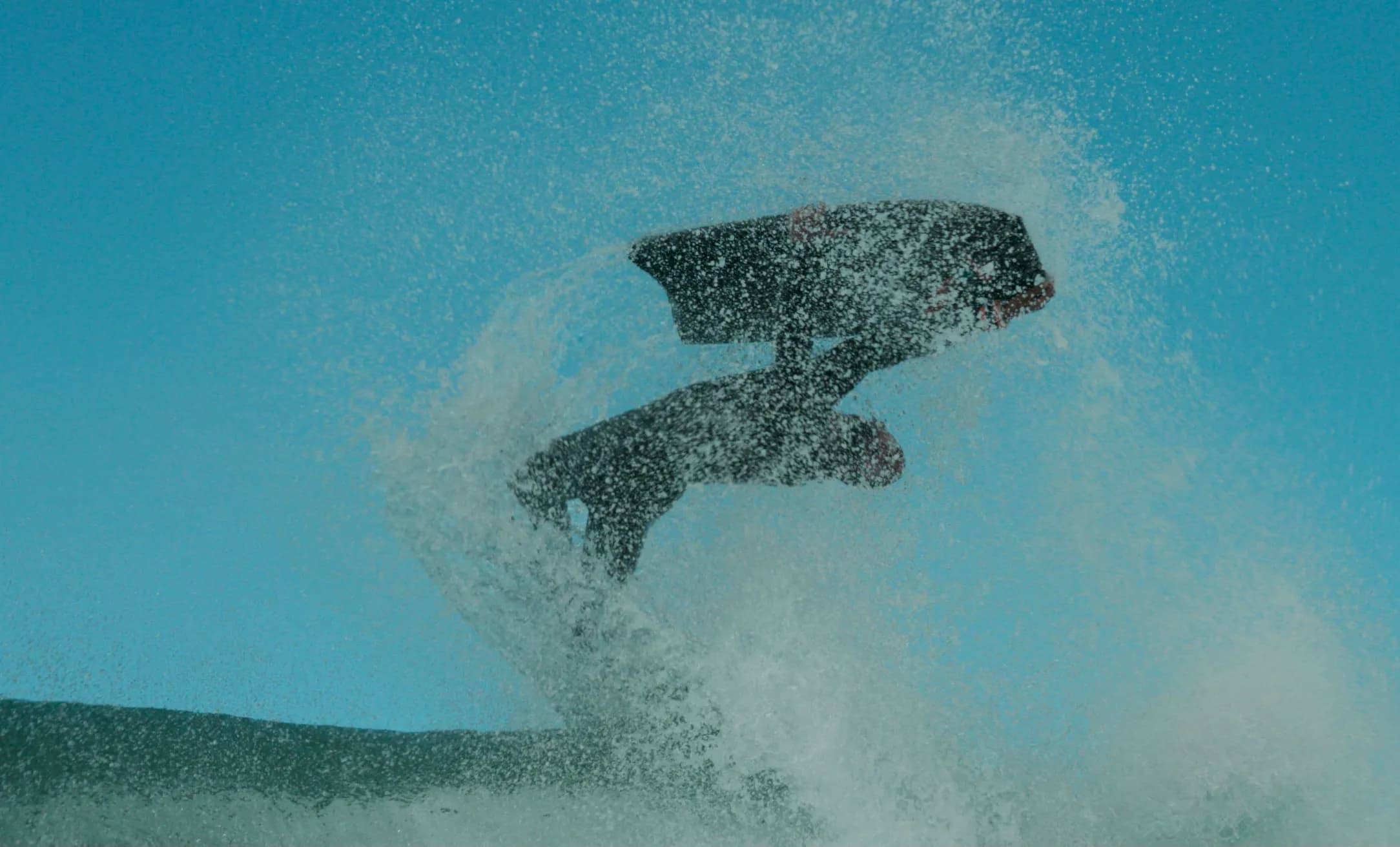 A swimmer suspended beneath the surface of blue water.